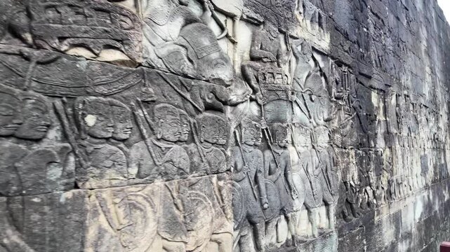 Detailed bas-relief at Bayon Temple, Angkor Thom, Cambodia &mdash; procession of warriors and nobles, intricate stone carvings depicting Khmer life