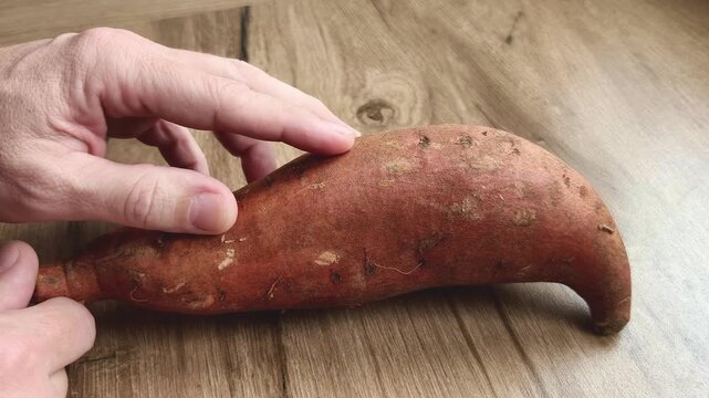 Manos presentando boniatos crudos para cocinar