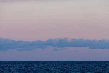 Obraz premium Minimal ocean horizon at pastel sunrise with calm sea