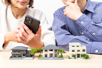 住宅模型を見ながら話し合いをする夫婦