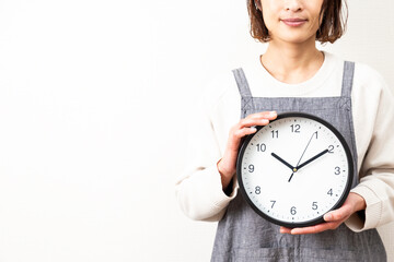 白背景に時計を持つ主婦