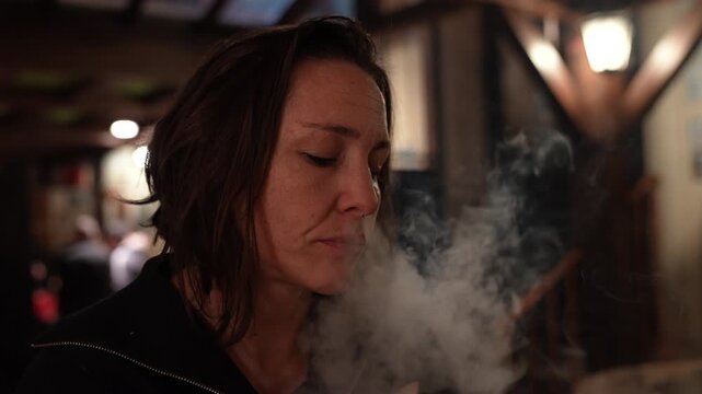 portrait of a young woman smoking cigarette in a bar- adiction concept