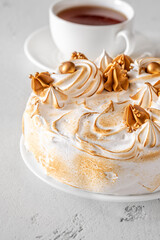 Madonna honey cake topped with toasted meringue and golden decorations flat lay