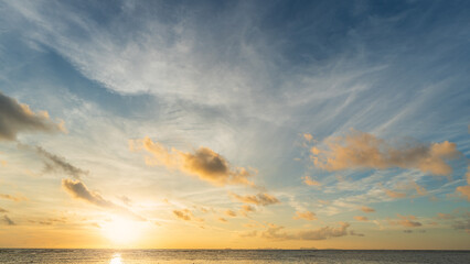 Sunrise sky cloud over sea water background in morning with orange, yellow sun light, Horizon sea ocean sunset sky landscape nature backgrounds and gold sun down in golden hour summer season, Dusk sky