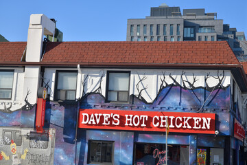 Fototapeta premium sign on the exterior of Dave's Hot Chicken, a restaurant that offers a poultry menu, located here at 2066 Yonge St (at Lola Rd), Toronto