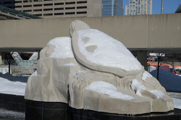 Fototapeta premium snow covered stone Turtle Sculpture by Solomon King at Spirit Garden at Nathan Phillips Square, Toronto