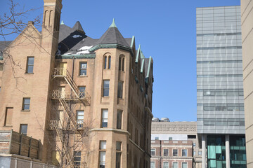 Fototapeta premium contrast of architectural styles: (left) Stewart Building designed by Edward James Lennox, completed 1894, in Richardsonian Romanesque, located at 149 College St, Toronto