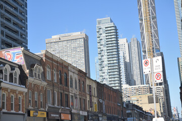 Fototapeta premium looking northwest on Yonge St from Wellesley St E to historic commercial and residential shops incl signs, Toronto
