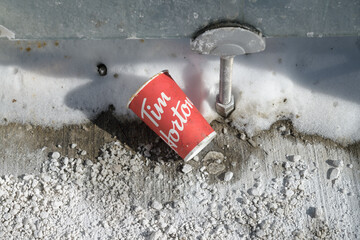 Fototapeta premium grungy discarded Tim Hortons beverage cup inside a bus shelter, winter time, Toronto