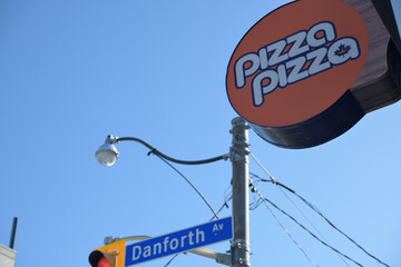 Fototapeta premium round projecting Pizza Pizza sign at 85 Danforth Av intersection of Broadview Av, Toronto