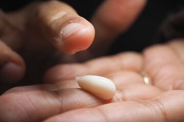Holding a small white object in a hand
