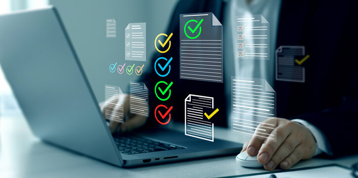 Business person checking digital documents on laptop with checklist approval icon, verification, workflow control, productivity and online document management.	

