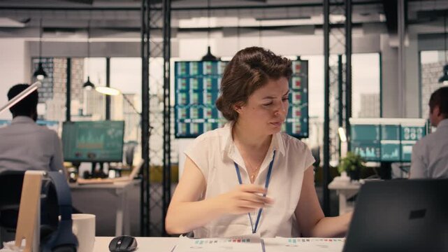 Female worker documenting essential ideas and writing on notebook, scheduling tasks and doing research for KPI. Drafting handwritten notes for business intel that reflects objectives.