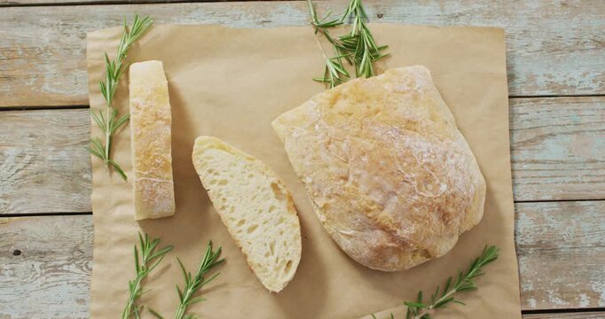 Video of rosemary and brad on baking paper on wooden worktop