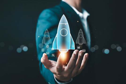 Businessman holding digital rocket with business icons, symbolizing startup launch, innovation, growth strategy, digital transformation, technology investment, and future business success concept.