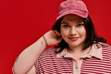 Naklejka premium Stylish plus size woman exuding confidence in vibrant red backdrop
