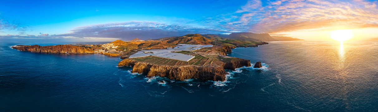 Cinematic aerial sunset over Sardina del Norte lighthouse and colorful coastal village in Gran Canaria