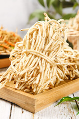 Fresh Dried Enoki Mushroom Bundles on Wooden Board