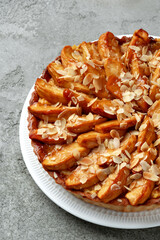 Fototapeta premium Baked apple pie with almond slices on a white plate ready to serve