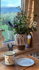 A vase with a bouquet of wildflowers  on a windowsill