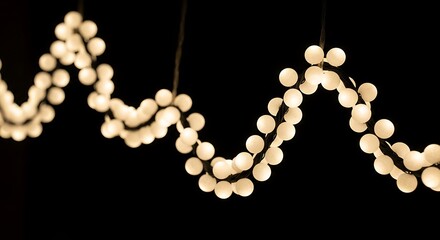 Wavy string lights with white bulbs on black background