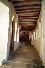 Fototapeta premium Vertical photo of a typical arcaded street in Miravet, Tarragona, Catalonia, in morning light