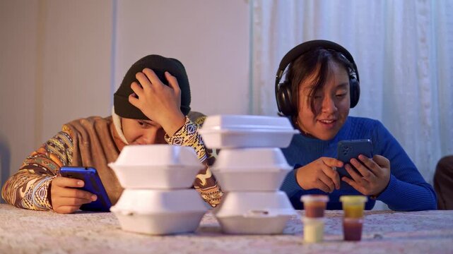 Distracted latino teens ignoring fast food dinner