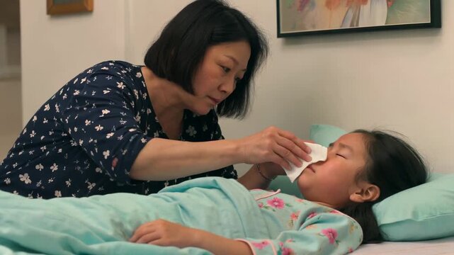 Mother takes care of bedridden child, wipes face, mother takes care of sick woman