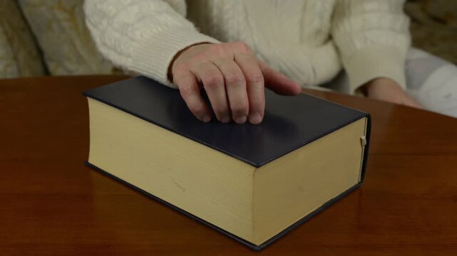 Fingers scratching a faux leather book cover with sound