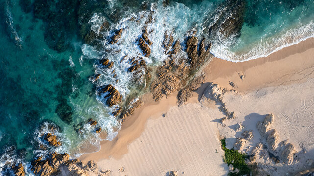 Aerial view of the beach with waves breaking on the shore in Baja California Sur, Mexico.