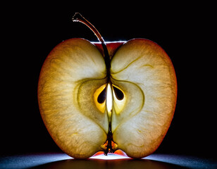 Luminous backlit apple slice featuring intricate inner textures and seeds. This dramatic crosssection symbolizes health and nature, perfect for highend food and lifestyle branding projects.