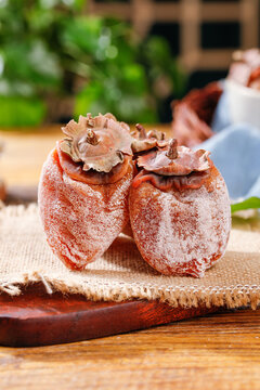 Dried Frost-Covered Persimmons on Wooden Board - Traditional Asian Preserved Fruit Delicacy