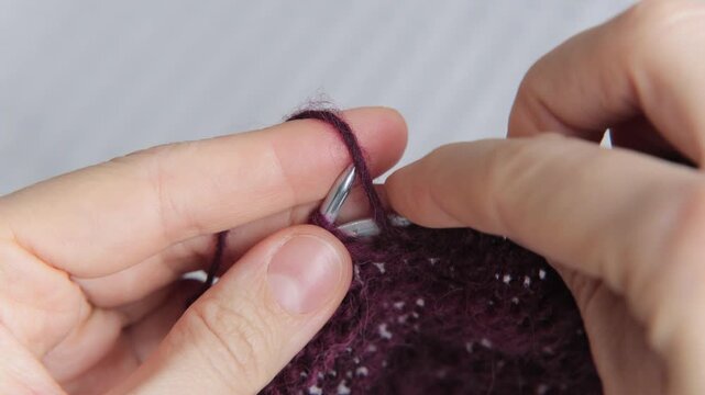 woman knits wool clothes on knitting needles. skills of making clothes from yarn, hobbies meditation. woman knits soft purple sweater at home. mental health, develop fine motor skills hands. handmade.