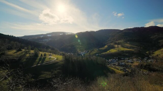 Static time-lapse of the Waldenburg valley in Switzerland, showing the sun shining over the rolling hills, the village, and the rural landscape of Basel-Landschaft.