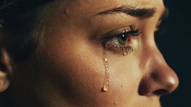 Woman crying with a single tear rolling down her cheek
