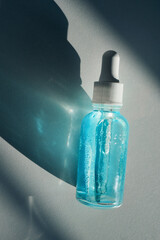 Blue liquid two-phase skincare serum in dropper bottle showing hydration and cosmetic beauty