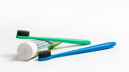 A two toothbrush with toothpaste on white background with copy space, close-up. Dental oral hygiene concept.