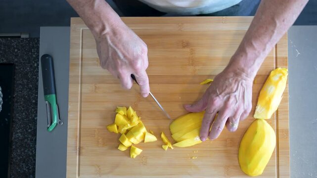 Person cutting a mango with a knife