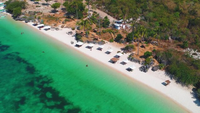 Aerial shot of beachfront umbrellas and tropical coast in clear water