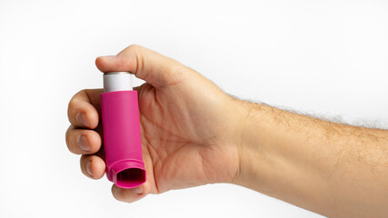 Hand holding asthma inhaler,Bronchodilator for relief asthma attack on white background. Pharmaceutical products is used to prevent and treat wheezing and shortness of breath caused asthma or COPD.