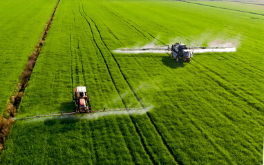 Agricultural Sprayers Applying Fertilizer to Green Wheat Fields © DoMinh