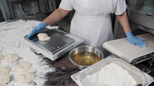 Baker weighing dough portions in a commercial kitchen
