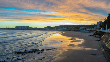 A beautiful sunset over the ocean with a beach in the background © Vctor