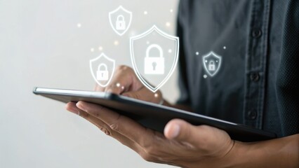 Person using tablet with digital padlock icons representing cybersecurity and data protection overlayed on the image.
