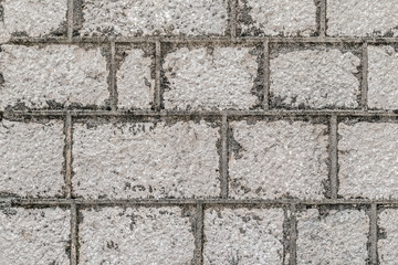 Fototapeta premium Ancient grey stone wall texture with rough masonry blocks. Authentic weathered limestone background of a historic building on Njegoseva street in Cetinje, Europe