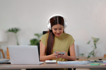 Young woman wearing headphone listening music on smartphone
