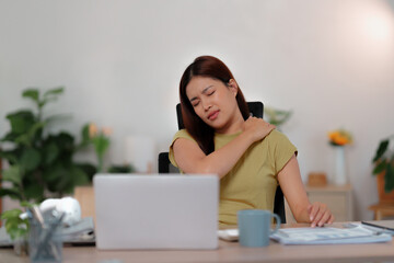 female is demonstrating suffering from shoulder pain at home