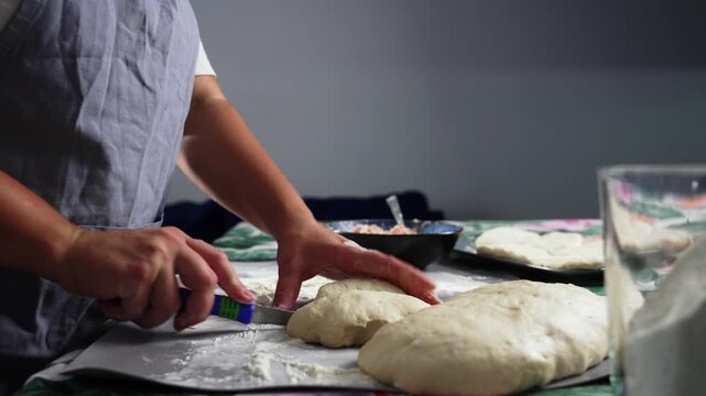The hostess cuts off a piece of loose dough and rolls it into a ball. High quality 4k footage