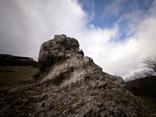 Formazione rocciosa naturale su pendio montano con masso scolpito dal tempo