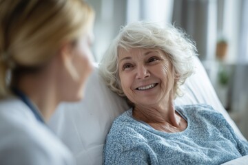 Smiling Elderly Patient in Hospital Bed Talking to a Female Doctor